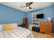 Bedroom showcasing blue walls, ceiling fan, and window for natural light at 2444 Fabyan Ln, Charlotte, NC 28262