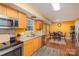 Eat-in kitchen featuring stainless steel appliances, wood-look flooring, and warm colored walls at 2444 Fabyan Ln, Charlotte, NC 28262