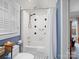 Bathroom with a shower and tub combination, tiled walls, and a window with natural light at 253 Misenheimer Nw Dr, Concord, NC 28025