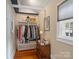 Walk-in closet with custom shelving, storage drawers, wood floors, and natural light at 253 Misenheimer Nw Dr, Concord, NC 28025