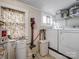 Functional laundry room with a washer, dryer, utility sink, and storage shelving at 253 Misenheimer Nw Dr, Concord, NC 28025