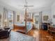Serene main bedroom with hardwood floors, four-poster bed, and ample natural light from large windows at 253 Misenheimer Nw Dr, Concord, NC 28025