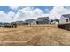 View of backyards of homes in a housing development under a cloudy sky. Brown lawns in the foreground at 3009 Bent Willow Dr # 160, Indian Trail, NC 28079