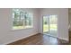 A bright living room has hardwood floors, large windows and a sliding glass door at 327 Brinkley Dr # 107, Kings Mountain, NC 28086