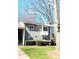 Gray home with an attractive bay window, trimmed shrubbery, and a beautiful tree in the front yard at 3240 Heathstead Pl, Charlotte, NC 28210