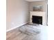 Open living room with a white fireplace, neutral walls, and a gray and white rug on vinyl floors at 3240 Heathstead Pl, Charlotte, NC 28210