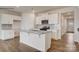 Bright kitchen showcasing white cabinets, a kitchen island with sink, stainless steel appliances, and wood flooring at 339 Brinkley Dr, Kings Mountain, NC 28086