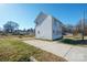 Exterior view of the backyard with a back entrance, small porch and concrete parking area at 418 N Pear St, Gastonia, NC 28054