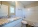 Modern bathroom features granite countertop vanity and tub with white tile at 418 N Pear St, Gastonia, NC 28054