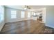 Open-concept living room showcasing wood-look flooring, large windows, and seamless flow into the kitchen at 418 N Pear St, Gastonia, NC 28054