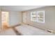 This living room has carpeted floors and two windows that provide natural light at 712 Stevens St, Gastonia, NC 28054