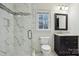 Bathroom featuring a stylish walk-in shower with unique tile and sleek vanity with marble countertop at 9128 Summer Club Rd, Charlotte, NC 28277