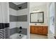 Stylish bathroom features a shower and an adjoining vanity with wood cabinets, black fixtures, and white countertops at 9128 Summer Club Rd, Charlotte, NC 28277