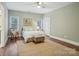 Comfortable bedroom with natural light, a rocking chair, and hardwood floors creating a cozy space at 9128 Summer Club Rd, Charlotte, NC 28277