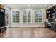 Bonus room with hardwood flooring, three windows, and a black cabinet at 9128 Summer Club Rd, Charlotte, NC 28277