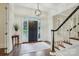 Elegant foyer with staircase, dark door, and hardwood floors at 9128 Summer Club Rd, Charlotte, NC 28277