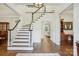 Bright foyer with hardwood floors, staircase, and elegant light fixture at 9128 Summer Club Rd, Charlotte, NC 28277
