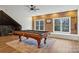 Spacious game room with a billiard table, exposed brick and chalkboard wall and plenty of natural light at 9128 Summer Club Rd, Charlotte, NC 28277