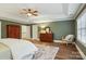 Spacious main bedroom featuring tray ceiling, hardwood floors, large windows, and a cozy sitting area with a rocking chair at 9128 Summer Club Rd, Charlotte, NC 28277