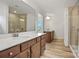 Modern bathroom featuring double vanities, wood-look floors, and glass-enclosed shower at 9481 Coast Laurel Ave # 12, Concord, NC 28027