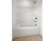 Clean white bathtub with shower head and built-in shelving at 9481 Coast Laurel Ave # 12, Concord, NC 28027