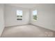 Bright bedroom with carpet, two windows, and neutral paint at 9481 Coast Laurel Ave # 12, Concord, NC 28027