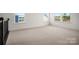 Spacious bonus room with plush carpeting and windows offering natural light at 9481 Coast Laurel Ave # 12, Concord, NC 28027