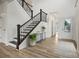 Bright foyer with a staircase featuring black iron spindles, wood floors, and neutral walls at 9481 Coast Laurel Ave # 12, Concord, NC 28027