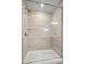 Glass-enclosed shower featuring beige, rectangular tiling and a shower head at 9481 Coast Laurel Ave # 12, Concord, NC 28027