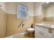 Well-lit bathroom featuring vanity with sink, toilet, window, and neutral tile surround at 111 Courtland St, Chester, SC 29706