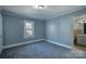 Cozy bedroom with a window, light blue walls, white trim, and gray carpet, next to the bathroom at 111 Courtland St, Chester, SC 29706