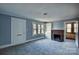 Bright living room with a gray carpet, a fireplace with brick surround, built-in shelving, and natural light at 111 Courtland St, Chester, SC 29706