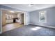 Living room with light blue walls, gray carpet, a window, and a view into the kitchen at 111 Courtland St, Chester, SC 29706