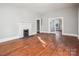 Living room featuring a decorative fireplace, hardwood floors, and large doorway to another room at 137 Lancaster St, Chester, SC 29706