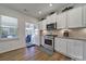 Well-lit kitchen with stainless steel oven and microwave, and view to a sunroom at 14032 Canemeadow Dr, Charlotte, NC 28278
