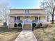 Charming two-story home with a welcoming front porch and American flag at 2021 Witmore Rd, Wingate, NC 28174