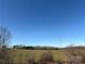 Scenic rural view with an open field, power lines, trees, and clear blue sky at 2084 W Memorial Hwy Rd, Union Grove, NC 28689