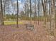 Backyard view with mature trees, a wooden fence and a decorative bench at 2405 Ivy Run Dr, Indian Trail, NC 28079
