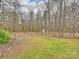 Expansive backyard featuring mature trees, a small outbuilding and a wooden fence at 2405 Ivy Run Dr, Indian Trail, NC 28079