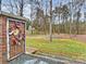 Backyard scene with brick column featuring art, green grass, a wooden fence and a small outbuilding at 2405 Ivy Run Dr, Indian Trail, NC 28079