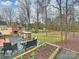 Spacious backyard with outdoor kitchen, seating area, wooded views, and decorative brick grill area at 2405 Ivy Run Dr, Indian Trail, NC 28079