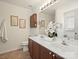 Bathroom featuring double sinks, framed mirror, wood cabinets, flower decor, and tile flooring at 2405 Ivy Run Dr, Indian Trail, NC 28079