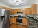 Kitchen showcases stainless steel appliances, oak cabinets, and plenty of storage at 2405 Ivy Run Dr, Indian Trail, NC 28079