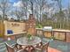 Outdoor kitchen with wooden table, stone floors, brick oven, built in grill and cabinets at 2405 Ivy Run Dr, Indian Trail, NC 28079