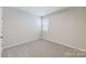 A clean and bright carpeted bedroom space with a window and white walls at 2656 Tillman St, Monroe, NC 28112