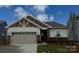 Charming single-story home with a two car garage, stone accents, manicured lawn, and inviting curb appeal at 2656 Tillman St, Monroe, NC 28112