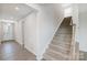 Entryway featuring vinyl floors, a carpeted staircase, and an entry door at 2656 Tillman St, Monroe, NC 28112
