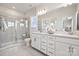 Modern bathroom features a glass shower, double vanity, and neutral tile flooring at 3218 Stelfox St, Charlotte, NC 28262