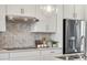 Modern kitchen boasts stainless steel appliances, white cabinets, and stylish backsplash at 3218 Stelfox St, Charlotte, NC 28262