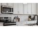 Kitchen with stainless steel appliances, white cabinets, quartz countertops, and subway tile backsplash at 3222 Stelfox St, Charlotte, NC 28262